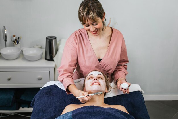 cosmetologist applying moisturizing facial mask face female customer skincare procedure modern beauty salon 935394 9743